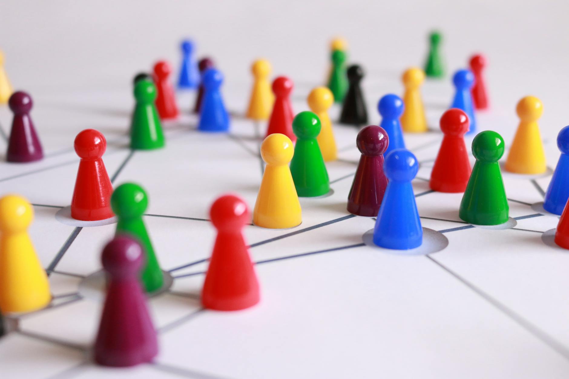 Un arrangement stratégique de pions colorés connectés sur un plateau de jeu, symbolisant le réseautage et le travail d'équipe.